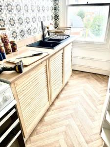a kitchen with a sink and a wooden floor at Central st Leonard’s Maisonette in St. Leonards
