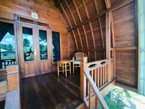 a porch of a wooden cabin with a table and chairs at Eling Ubud Guesthouse in Ubud