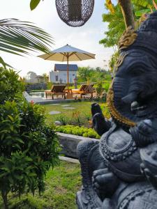 a statue of a lion in a garden at Eling Ubud Guesthouse in Ubud