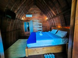 a bedroom with a bed in a wooden cabin at Eling Ubud Guesthouse in Ubud