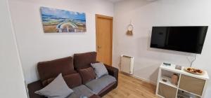 a living room with a couch and a flat screen tv at Mina La Camocha · 2 Hab · 4 pax · Wifi in Gijón