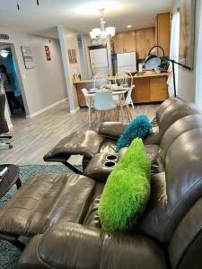 a living room with a leather couch with a green pillow at Exciting 2 B/1 b near FSU /FAMU. in Tallahassee