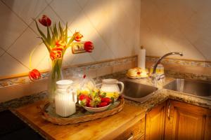 eine Küchentheke mit einer Vase aus Blumen und einer Schale Obst in der Unterkunft Casa rural Valtravieso in Las Navas del Marqués