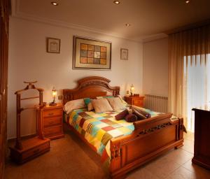 ein Schlafzimmer mit einem großen Bett mit einem Holzrahmen in der Unterkunft Casa rural Valtravieso in Las Navas del Marqués