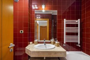 a red tiled bathroom with a sink and a tub at Spacious 2BR apartment with free parking in Lisbon by Soulplaces in Lisbon