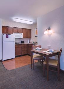 a kitchen with a table and a white refrigerator at Residence Inn Columbia in Columbia