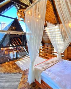 a bedroom with a bed with white mosquito net at Irmak Vadi Bungalov Zonguldak 