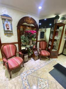 une chambre avec deux chaises et un miroir dans l'établissement Hotel Ciudad de Vitoria, à Santiago