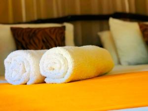 - une pile de serviettes assises au-dessus d'un lit dans l'établissement Atha Safari Resort & Riverside Camping, à Uda Walawe