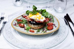 a plate of food with an egg on a table at The George Hotel Pangbourne in Pangbourne