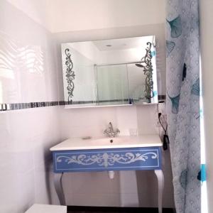 y baño con lavabo azul y espejo. en La Douce Parenthèse - 3 chambres d'hôtes-Accueil motards en Montirat
