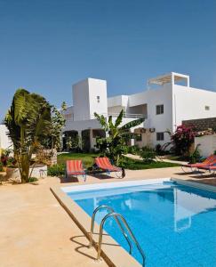- une piscine en face d'une maison dans l'établissement Villa Saraba, à La Somone