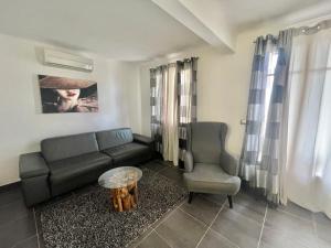 - un salon avec un canapé et une chaise dans l'établissement APPARTEMENT 2 CHAMBRES PROCHE CROISETTE, à Cannes