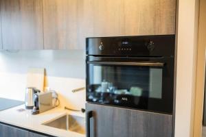 een zwarte oven in een keuken met een aanrecht bij Alphabet Apartments 1BR serviced apartments in Hilversum