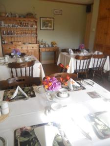 a dining room with a white table with flowers on it at Hillside Haven in Tahilla