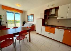 een keuken met een tafel en rode stoelen in een kamer bij Luminous flat in residence with pool in Veneto