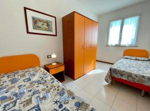 een hotelkamer met 2 bedden en een kast bij Luminous flat in residence with pool in Veneto