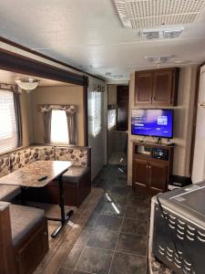 an rv living room with a tv and a table at Hideout by Glampers Camp in Port Charlotte
