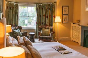 een slaapkamer met een bed en stoelen en een raam bij King John Inn in Tollard Royal