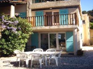 biały stół i krzesła przed domem w obiekcie Bel appartement duplex avec terrasse et jardin face à la plage de Gigaro w mieście La Croix-Valmer
