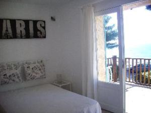 biała sypialnia z łóżkiem i dużym oknem w obiekcie Bel appartement duplex avec terrasse et jardin face à la plage de Gigaro w mieście La Croix-Valmer