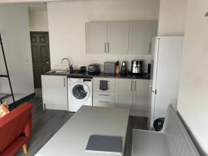 a kitchen with a washing machine and a refrigerator at Quirky and Cosy Self Contained Flat, Ferryhill Near Durham in Ferryhill