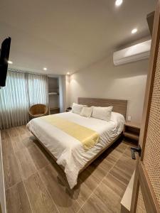 - une chambre avec un grand lit et une couverture jaune dans l'établissement Hotel Buena Vista, à Bucaramanga