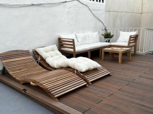 a patio with two benches and two chairs on a deck at Disfruta, nuevo en Mentidero in Cádiz