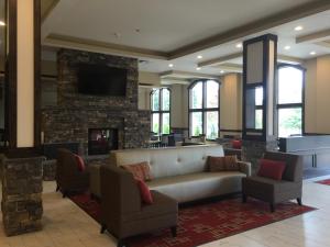 eine Lobby mit einem Sofa, Stühlen und einem Kamin in der Unterkunft Quality Inn & Suites Tacoma - Seattle in Tacoma