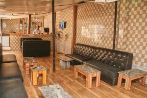 un soggiorno con divano e tavoli in pelle nera di GLAMOUR PARK'S HOTEL, ABUJA ad Abuja
