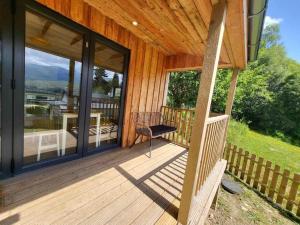 a porch of a house with a chair on it at Grianach Cabin, Relaxing Getaway with Unique Charm in Roybridge