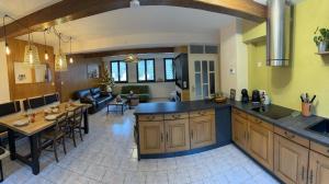 a kitchen and living room with a table and a counter top at La tanière in La Broque