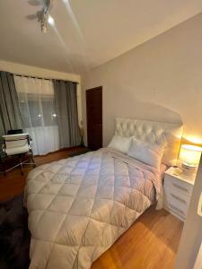 a bedroom with a large white bed in a room at Habitacion en Carrasco Sur, cerca del aeropuerto y la rambla in Montevideo