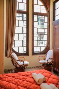 1 dormitorio con 2 sillas, 1 cama y 2 ventanas en Galeón Nouveau (Apt 03). Terrace in The Oldtown, en Montevideo