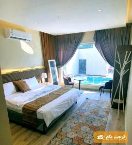 a hotel room with a bed and a large window at شاليهات z5 الفندقية in Al ‘Awājīyah