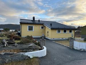 a yellow house with a fence in front of it at House close to Ålesund center in Ålesund