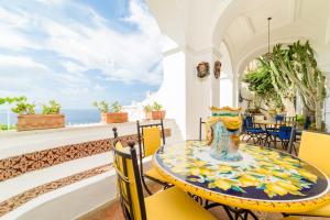 une salle à manger avec une table et des chaises et l'océan dans l'établissement Estate4home - Villa Elsa, à Positano