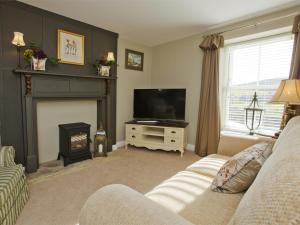 a living room with a television and a fireplace at 1 Bed in Pateley Bridge G0015 in Pateley Bridge