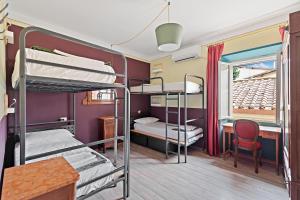 a dorm room with bunk beds and a table and a desk at Ostello Bello Firenze in Florence