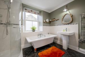 une salle de bain avec une baignoire, un lavabo et une douche dans l'établissement Mae Cottage, à Richmond 29 autres photos