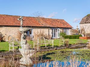 une maison avec des chaises et une statue à côté d'un étang dans l'établissement 2 Bed in Chippenham 77333, à Chippenham