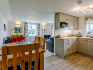 a kitchen and a living room with a table and chairs at 3 Bed in Wellington 78595 in Sampford Arundel