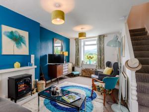 a living room with blue walls and a fireplace at 1 Bed in Porthmadog 78300 in Penrhyndeudreath