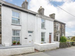 an old stone house with white walls and windows at 1 Bed in Porthmadog 78300 in Penrhyndeudreath