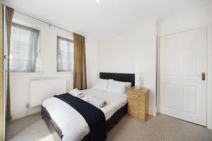 sypialnia z łóżkiem, oknem i drzwiami w obiekcie Stunning 4-Bed Apartment w Londynie