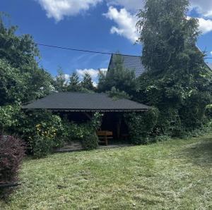 um gazebo com um banco num quintal em Agroturystyka u Kwiatka em Janów Podlaski