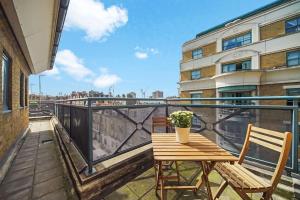 a wooden table and two chairs on a balcony at Stunning 4-Bed Apartment in London