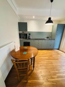 a kitchen with a wooden table and a wooden floor at Élégance Parisienne pour 4 personnes in Paris