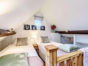 2 camas individuais num quarto no sótão com uma janela em 3 Bed in Chippenham 77334 em Chippenham