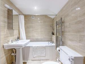 a bathroom with a sink and a tub and a toilet at 3 Bed in Chippenham 77334 in Chippenham